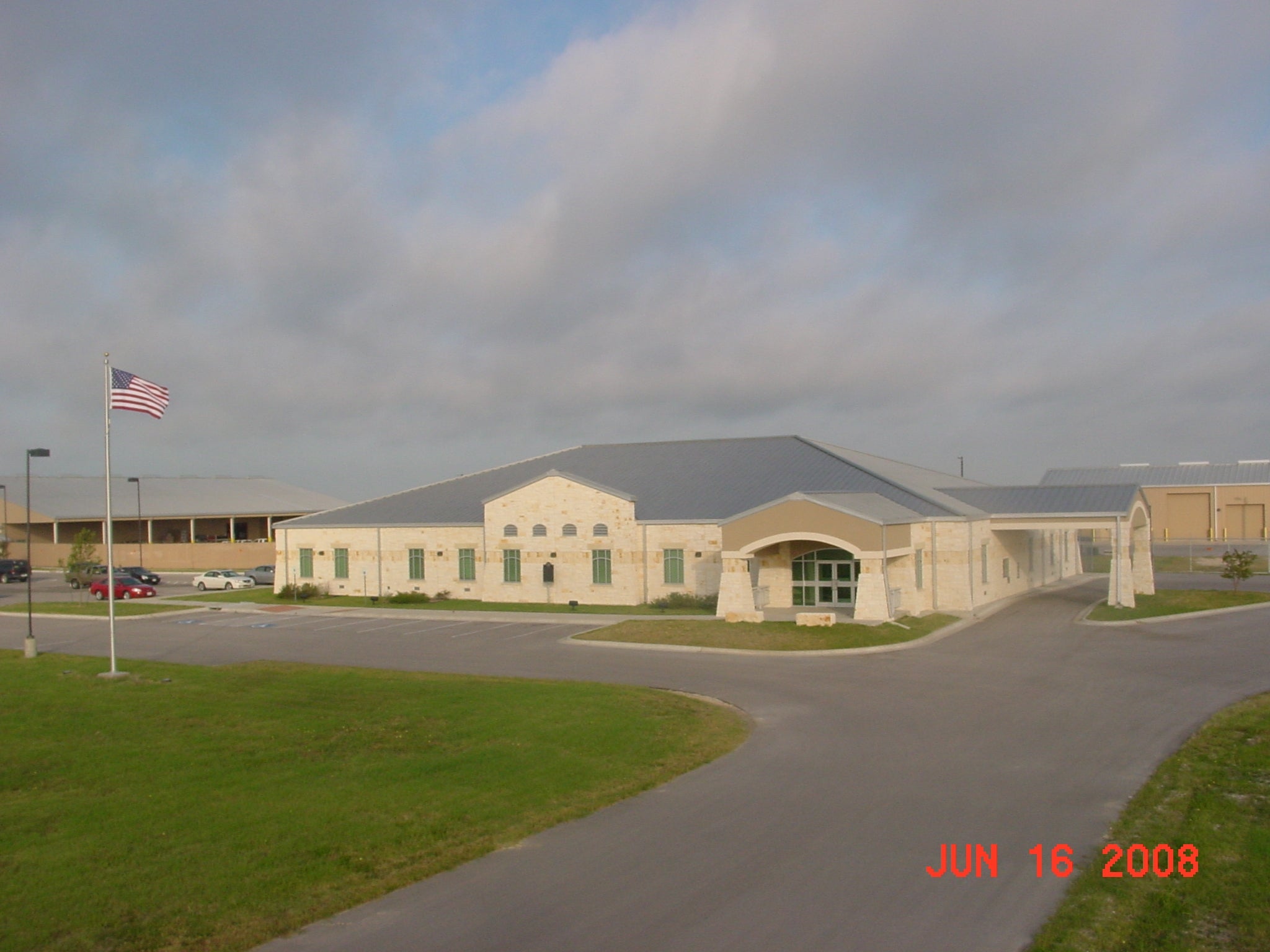 Exterior view of Bartlett Electric Cooperative headquarters building with parking lot, American flag, and service facilities in Texas